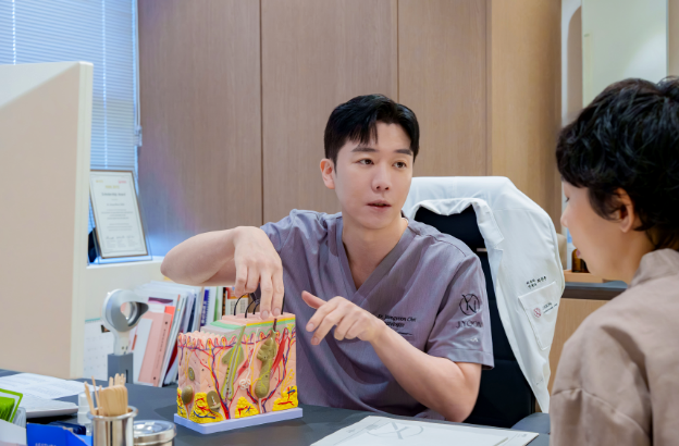 제이윤피부과에서 피부 모형을 보며 콜라겐 부스터 상담을 진행하는 모습